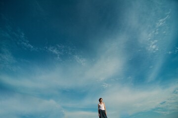 Girl in jeans and white T-shirt poses in nature