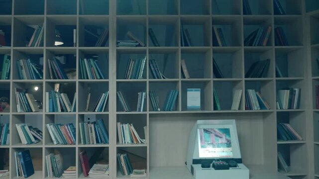 In the library where you can find information by scrolling on the display of the device, which uses the old microfiche archiving technology. Shot in motion
