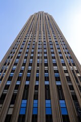 Towering skyscraper with intricate architectural design against a clear blue sky