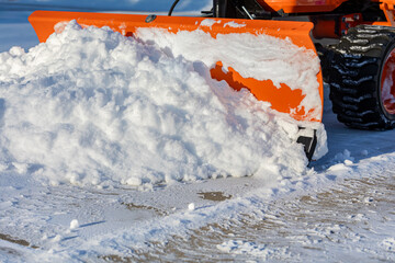 Snow removal from driveway with snowplow. Winter weather safety, home maintenance, and snowstorm...