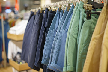 Men's colored shorts on display at a clothing store in a shopping mall.