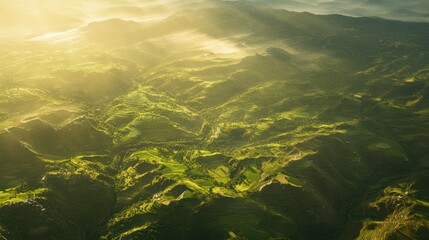 Obraz premium Aerial view of an ancient, terraced mountain landscape, green fields glowing under the sun.