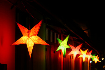 Many colorful star shaped lanterns illuminate a street in the old town of Luang Prabang at night, Laos