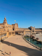 Naklejka premium Holiday vibes at Plaza de España in Seville, Spain — ideal for sightseeing, walking tours, and capturing the essence of a Spanish getaway.