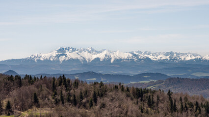 Snow-capped mountain peaks - Tatra mountains. View from the observation tower on the top of Koziarz mountain in Beskidzkie Sądeckie. Tatra panorama. Panorama ośnieżonych Tatr