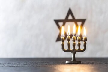 Fototapeta premium A lit menorah in front of a star symbolizing Jewish tradition, with a blurred background, creating a serene atmosphere.