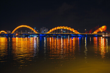 Obraz premium Dragon Bridge over the Han River is a famous landmark in the city of Da Nang in Vietnam at night with a golden backlight