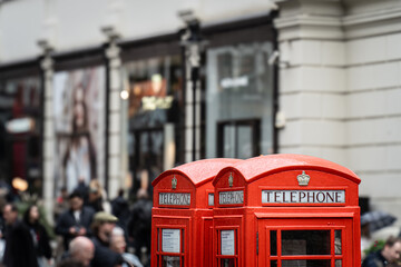 Classic red British telephone boxes on a bustling London street, symbolizing traditional urban...