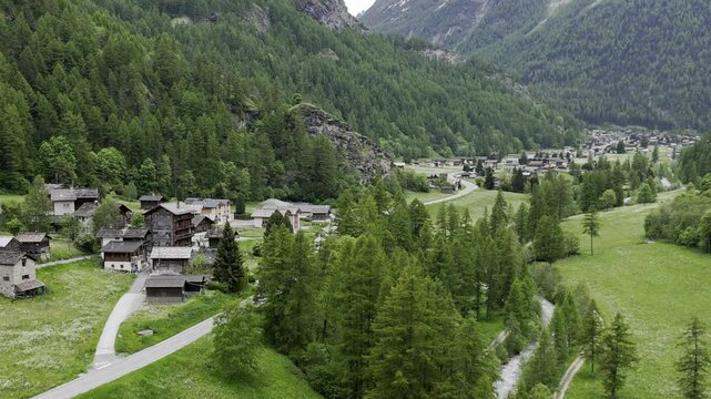 Stunning aerial footage of the picturesque Swiss village of Evol&egrave;ne, nestled in the heart of the Alps, traditional alpine chalets and breathtaking views of mountains and lush green