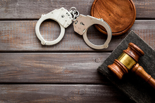 Metal handcuffs with judges gavel and criminal code book. Criminal law and justice concept