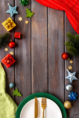 Table setting flatlay for Christmas and New Year Eve. Empty plate with cutlery and decoration, top view