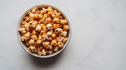 A bowl of caramel popcorn neatly arranged on a white background, perfect for movie night snack concepts or casual gatherings.