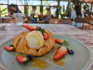 vanilla ice cream on croissant with fresh strawberry and blueberry