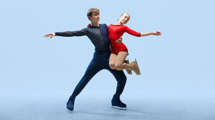 Professional ice skating partners perform difficult lift, show their elegance against cold blue background. Artistic ice dance. Concept of winter sport, elegance and grace, championship. Ad