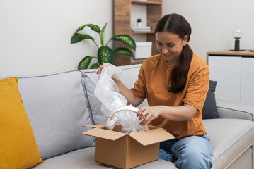 Express Convenience: She unpacks her goods on her sofa, celebrating her online purchase and the...