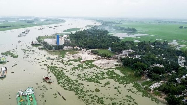 Drone arial view of Jamuna river Bangladesh, boat, ship, bulkhead moving through the river, life of riverbank people, 