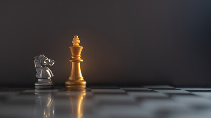 A chess game with a silver king and a gold king