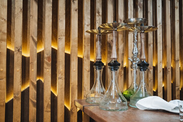 An Elegant Display of Beautiful Glassware Set Against a Warm, Rich Wooden Wall, Enhanced by Soft,...
