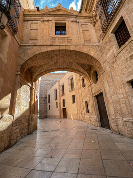 Arch bridge between buildings on Barchilla street in Valencia, Spain