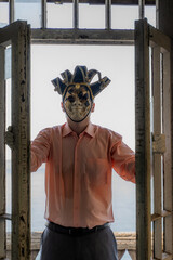 A man in a Venetian mask at the door