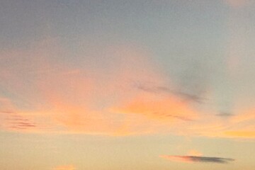 Beautiful sky during sunset or sunrise. The clouds are a perfect blend of warm orange and soft pink. The gradient makes this scene look calm and peaceful.