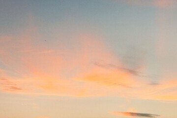 Beautiful sky during sunset or sunrise. The clouds are a perfect blend of warm orange and soft pink. The gradient makes this scene look calm and peaceful.