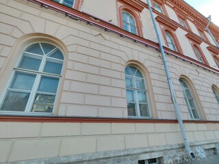 two-story classical building with intricate architectural details, large windows, and a light blue facade. The structure highlights the importance of preserving historical buildings in modern urban