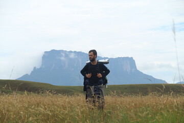 homem em trilha com monte roraima ao fundo