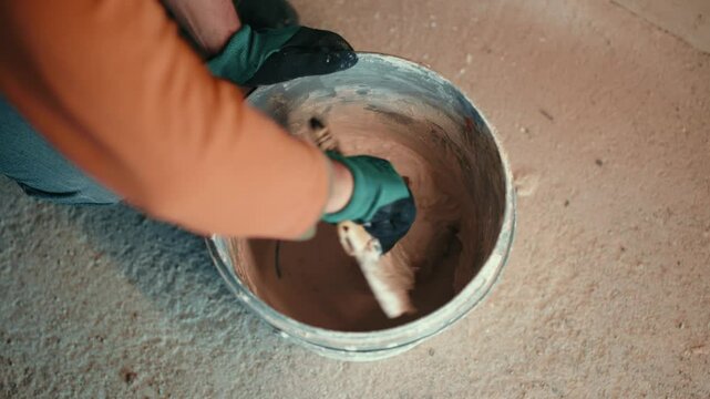 Professional worker plastering wall with putty knife, closeup
