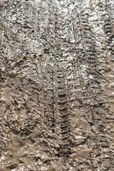 Texture of a dirty rural road with tire prints, top view
