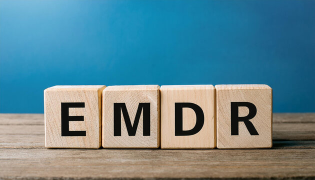 Wood cubes with abbreviation EMDR on table. Eye Movement Desensitization and Reprocessing.