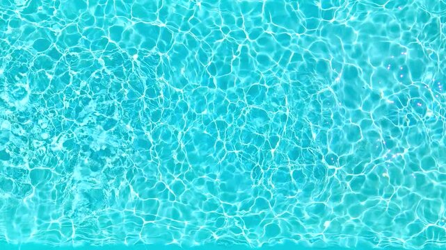 Blue water in the swimming pool with light reflections. Slow motion