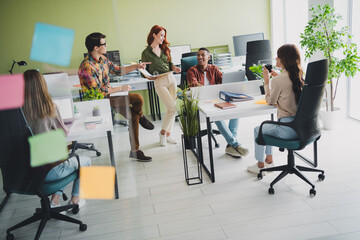 Photo of young age company graphic designers project managers working together on new creative idea brainstorming at office