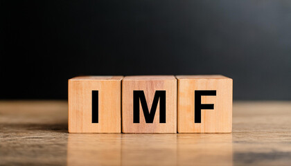 Wood cubes with abbreviation text IMF on wooden table. International Monetary Fund.