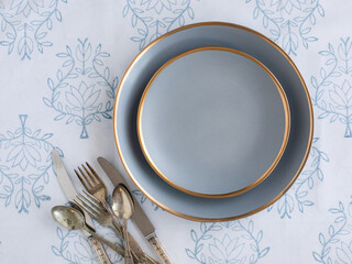 damask tablecloth with blue plates and cutlery