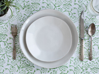 place setting on a green printed tablecloth