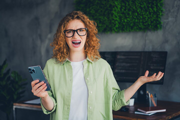 Photo of impressed confused lady programmer dressed shirt glasses texting modern device indoors...