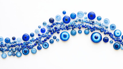Fototapeta premium Imagine a series of blue eye beads arranged on a crisp white background, starting with tiny beads at one end, their deep azure hues glistening like the ocean. 