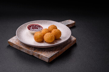 French fries balls with breaded brie or camembert cheese with sweet berry sauce