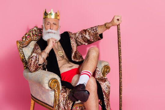 Photo of an eccentric man king lord wear luxurious trendy bathrobe sit throne for casino winners isolated on pink color background