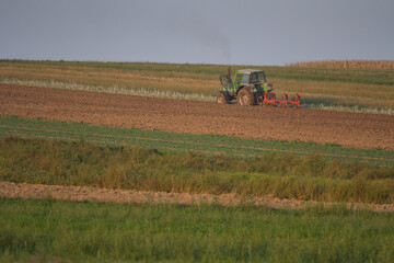 Agriculture machinery in action a tractor plows a field on a bright day © Bagatela