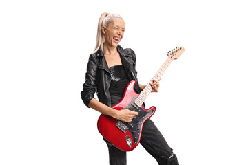 Fototapeta premium Cheerful female rock musician playing a guitar