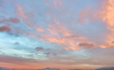 Obraz premium A beautiful sky tinted by the sun leaving vibrant shades of gold, pink, blue and multicolored. Clouds in the twilight evening and morning sky. Cloudy sky background in the evening, and during the day.