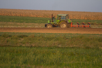 Agriculture machinery in action a tractor plows a field on a bright day © Bagatela