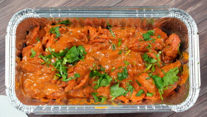 Mouth-watering dish a rich, creamy Indian curry. Chicken pieces coated in a spicy tomato sauce, garnished with fresh cilantro.