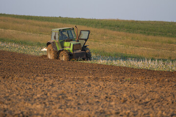 Agriculture machinery in action a tractor plows a field on a bright day © Bagatela