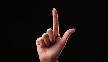 Hand with raised index finger on a black background