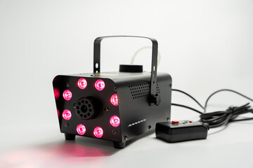 Black device with a red light. Black smoke machine connected to a power outlet