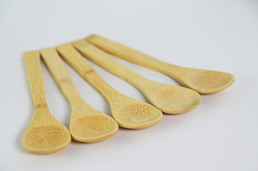 Five small yellow wooden spoons
