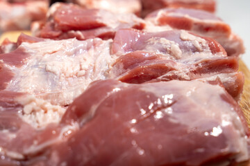 A close up of raw meat on a cutting board. The meat is cut into strips and he is fresh